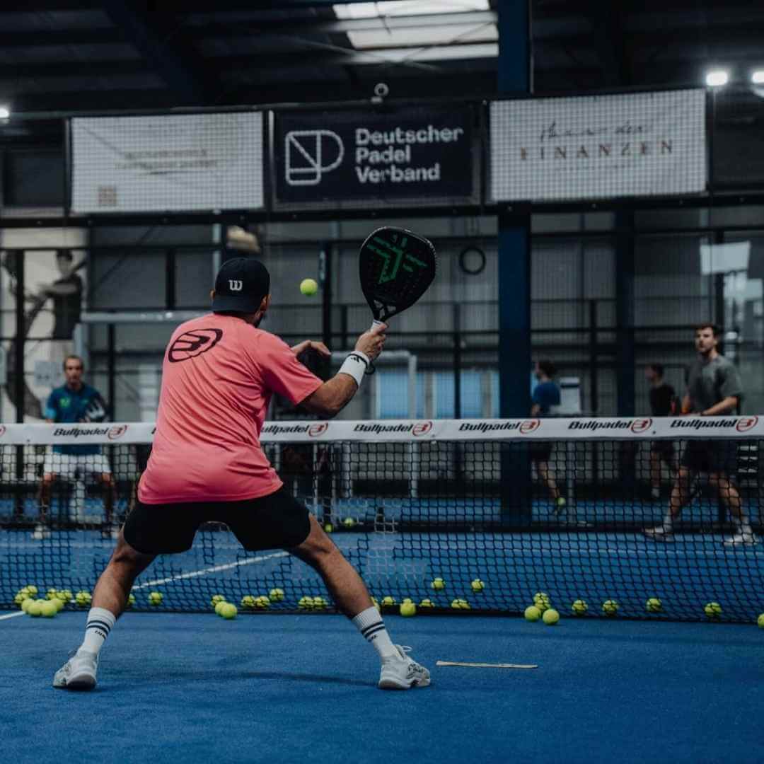 Padelspieler steht am Netz und schlägt den Ball
