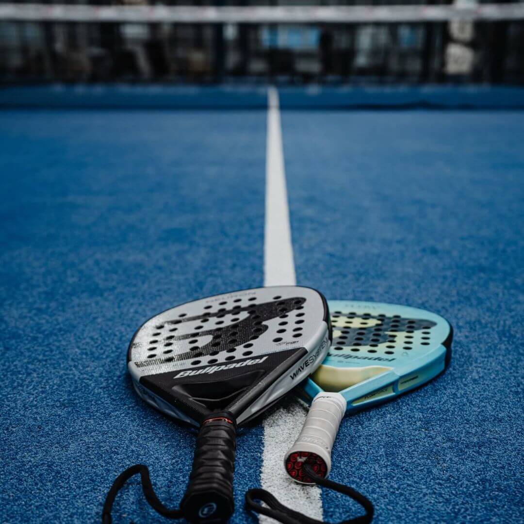 Zwei Padelschläger liegen auf dem Court